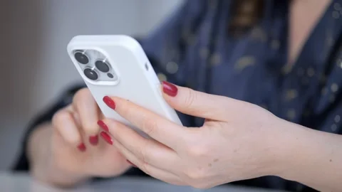 A woman is holding a white iPhone and texting Stock Footage 299788198