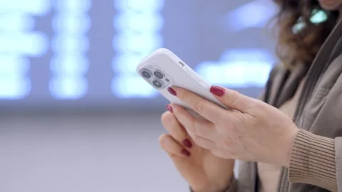 Woman is holding a white iPhone and looking at it Stock Footage 304192353