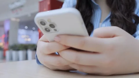 Woman is holding a white iPhone in her hand Stock Footage 306575868