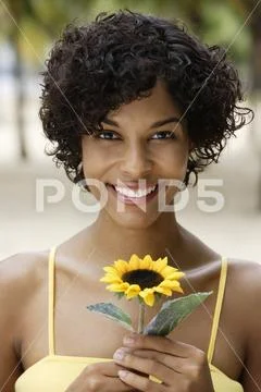 Woman holding yellow sunflower and smiling Stock Photos
