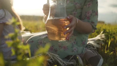 A woman holds a decanter with a drink. The drink in the decanter glows in the Stock Footage
