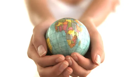 Woman holds up globe against white background Stock Footage