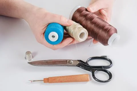 Woman holds spools of thread of different colors in her hands Stock Photos