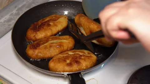 Woman at home kitchen preparing fried pies with filling Stockbeeldmateriaal 197873439