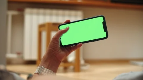 Woman at Home Lying on a Couch using Smartphone with Green Mock-up Screen, Doing Stock-Footage 111407296