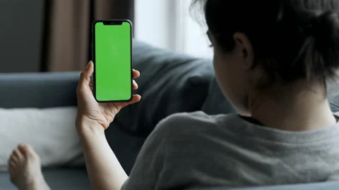 Woman at Home Lying on a Couch using Smartphone with Green Mock-up Screen Stock Footage 155681024