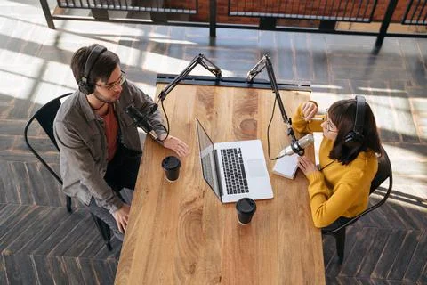 Woman host interviewing a guest while recording live podcast Stock Photos