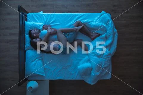 The woman hug a man on the bed. evening night time. view from above Stock Photos