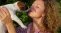 Woman Hugging and Kissing Cute Small Puppy Outdoors HD Footage
