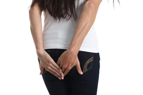 Woman with indigestion stands with back holding hand on butt Stock Photos
