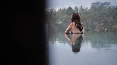 Woman in infinity pool with rainforest view 109 Stock Footage 264574284