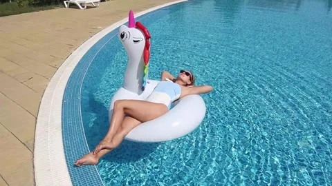 Woman on inflatable unicorn pool float in pool in hotel. Summer holidays, en Stock Footage 268448885