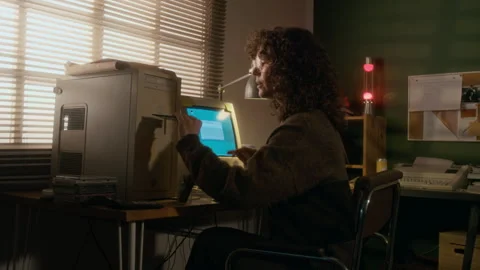Woman Inserting Floppy Disk while Working on Report on Vintage Computer Stock Footage 327239405
