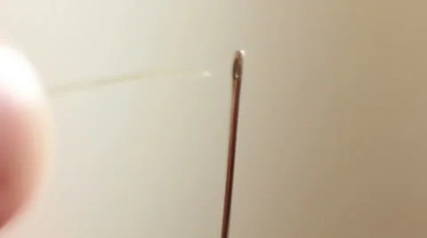 The woman inserts the thread through the needle Stock Footage 57261386