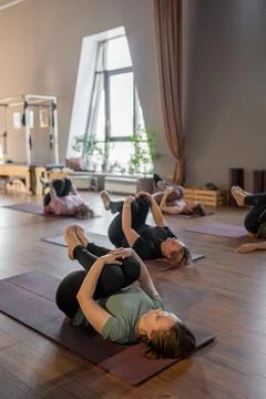 Woman instructor teaching mobility to a group of seniors in a pilates studio Photos