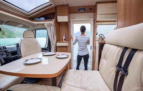 Woman in the interior of a camper RV motorhome with a cup of coffee looking a Stock Photos