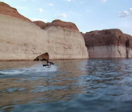 Woman on jet ski with red rock cliffs Stock Footage