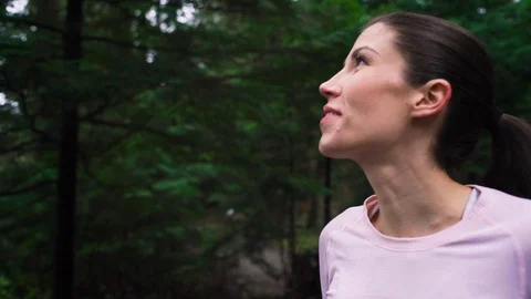 Woman jogging on forest path stops to enjoy nature Stock Footage 95643331