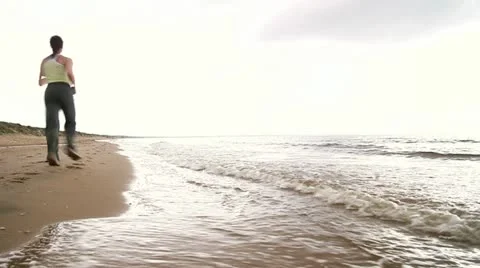 A woman jogging by the sea Stock Footage