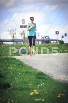 Woman Jogging Through The Rural Landscape