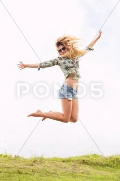 Woman jumping into the clouds Stock Photos