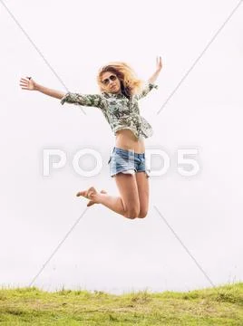 Woman jumping into the clouds Stock Photos