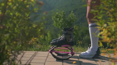 Woman jumping into the Kangoo Jump boots outdoors, video edited Stock Footage