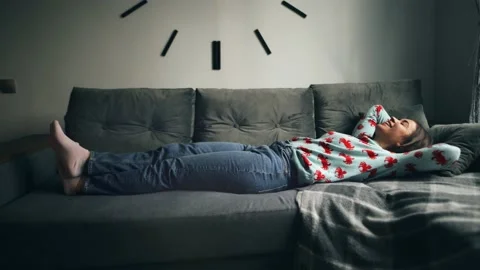 Woman jumping to lie down on a couch while celebrating moving to a new home Stock Footage 233428552