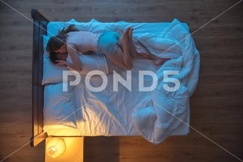 The woman kiss a man on the bed. evening night time. view from above Stock Photos