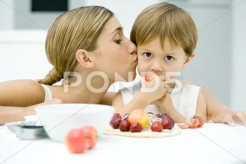 Woman Kissing Little Boy On Cheek, Boy Eating Apple