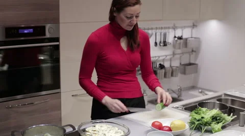 The woman in the kitchen cut the cucumber Stock Footage 59188324