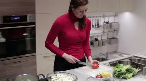 The woman in the kitchen cut the tomato Stock Footage 59188732