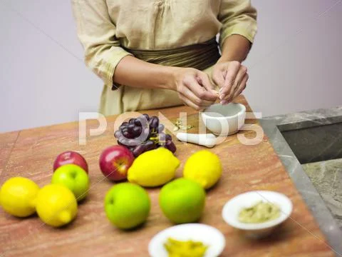 Woman in kitchen with fruits, mid-section Stock Photos