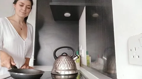 Woman in kitchen making breakfast and coffee Stock Footage