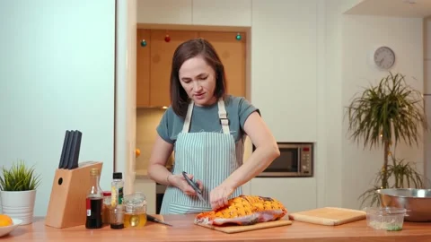 A woman in the kitchen opens a package of duck. Preparing a festive dinner. Stock Footage 170918902