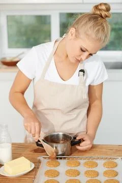 Woman, kitchen or chef baking cookies with dough or pastry pot in a bakery shop Stock Photos