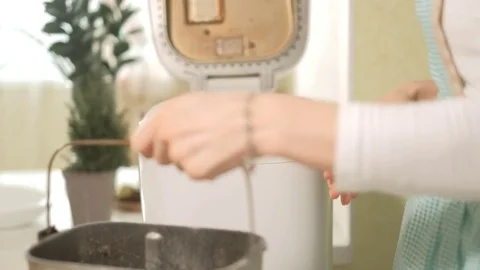 A woman in the kitchen prepares bread in a bread maker Stock Footage 85292736