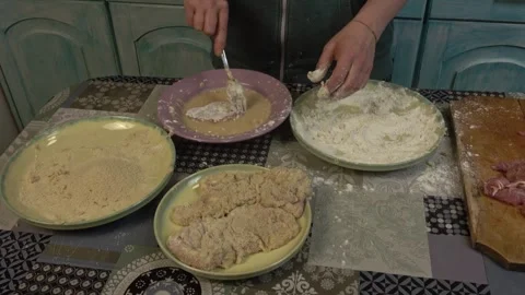 Woman in the kitchen preparing schnitzels 스톡 동영상 334522320