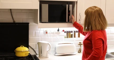 Woman in kitchen using microwave 2 Stock Footage 102067709