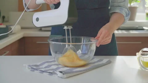Woman in the kitchen whipping eggs Stock Footage 199209727