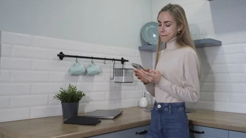 Woman in the kitchen writes down information in a notebook and picked up a phone Stock-Footage 260601392