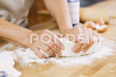 Woman Kneading Dough on Floured Counter in Kitchen Stock Photos