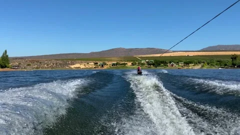 Woman on kneeboard behind speed boat on Bulshoek Dam, South Africa Stock Footage