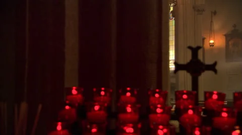 Woman kneeling and praying in sunlit nave of a Catholic church Stock Footage