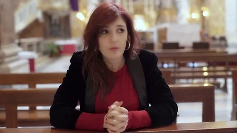 Woman kneeling praying in church Stock Footage