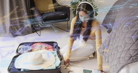 Woman kneeling by suitcase, using notebook, arranging clothes, placing hat, Stock Footage 323116475