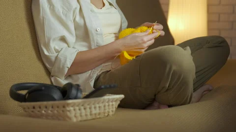 Woman knitting while relaxing on the couch. Stock Footage 332799271