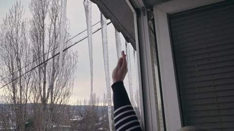 Woman knocks massive icicles outside the window Vidéo 103513478