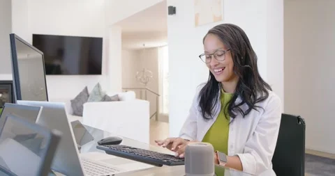 Woman in lab coat typing on wireless keyboard at desk, reacting to monitor 스톡 동영상 336686261