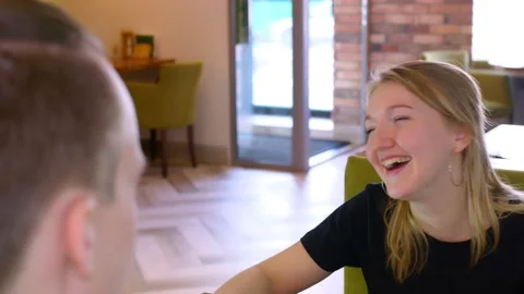 A woman laughs cheerfully while talking to her friend in a restaurant hall Stock-Footage 151729614